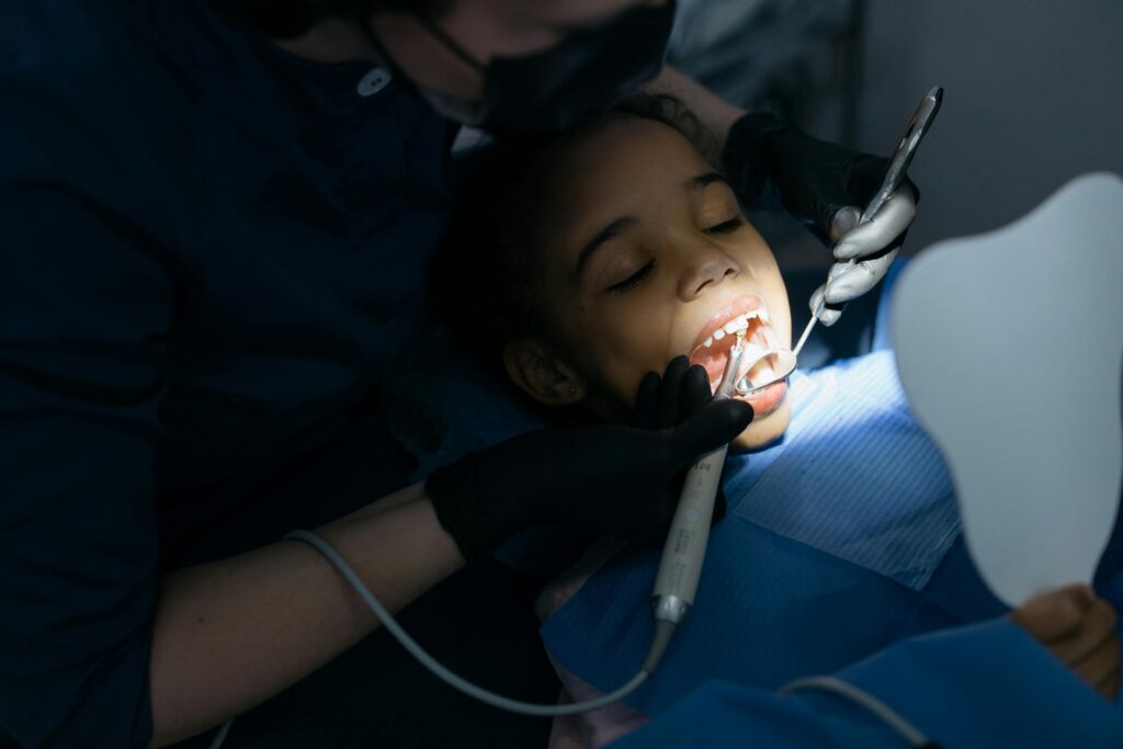 A young girl receiving a dental checkup at a clinic, highlighting oral care.